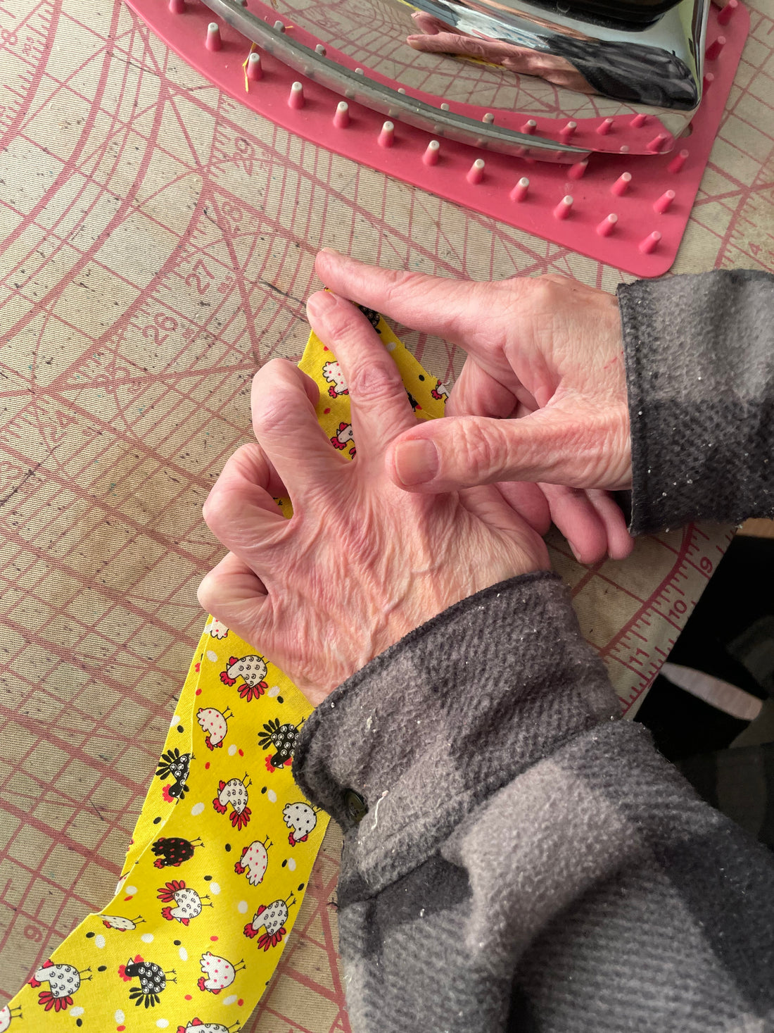 My Mom's hands showing me how to create binding for a quilt.